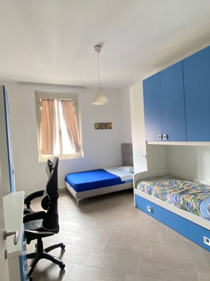 A dormitory room with a desk, chair, bunk beds, and a window with curtains. - Casa Vacanza Le Cinque Terre (La Spezia)