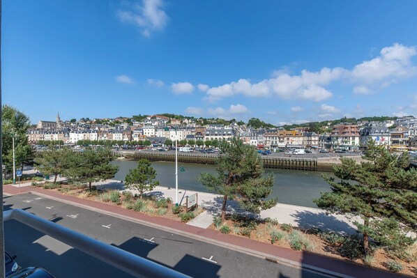 A coastal town with a river, buildings, and a parking area.