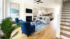 A spacious living room with a fireplace, a sofa, and a coffee table. - Magnolia Estate – 3 Private Quarters, Walk to Sites (Savannah)