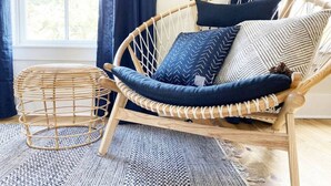 A wicker chair with a cushion and a woven basket on a patterned rug. - Magnolia Estate – 3 Private Quarters, Walk to Sites (Savannah)