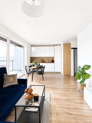 Un salon moderne avec un canapé, une table basse et une vue sur la cuisine et la salle à manger.