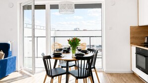 Una cocina moderna con comedor, un sofá azul y vistas a través de amplios ventanales.