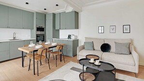 A modern kitchen with a dining area, a sofa, and a coffee table. - Authentic apartment - 3BR/8P - Clignancourt (Paris)