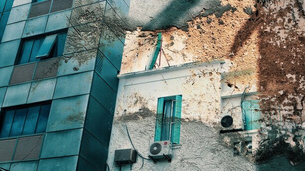 A building with a modern facade and traditional elements, including a window with a shutter and an air conditioning unit. - S+3 new Riadh Andalos Ariana (Ariana)