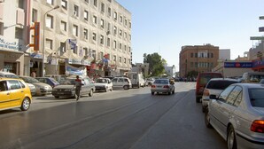 A busy urban street with multiple cars and pedestrians. - S+3 new Riadh Andalos Ariana (Ariana)