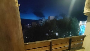 Une pièce dotée d’une grande fenêtre donnant sur une vue panoramique de la ville la nuit.
