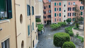 A narrow cobblestone street flanked by buildings with arched windows and balconies, leading to a gated entrance. - Arc Vatican Apartment-300 m from the Vatican (Roma)