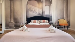 A large bed with pillows and towels, a chair, and a staircase in the background. - Arc Vatican Apartment-300 m from the Vatican (Roma)