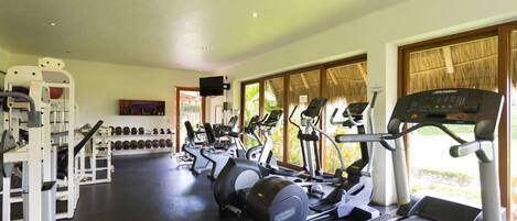 A gym with treadmills, elliptical machines, and weightlifting equipment.