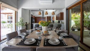 Un comedor moderno con una mesa redonda dispuesta para seis personas, rodeada de sillas.
