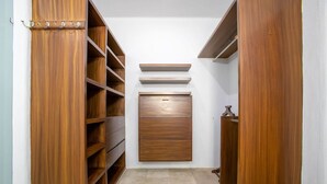 Vestidor con estantes de madera, un armario central y una barra para colgar.
