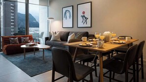 Un salon moderne avec un canapé, une table basse et une table à manger préparée pour le petit-déjeuner.