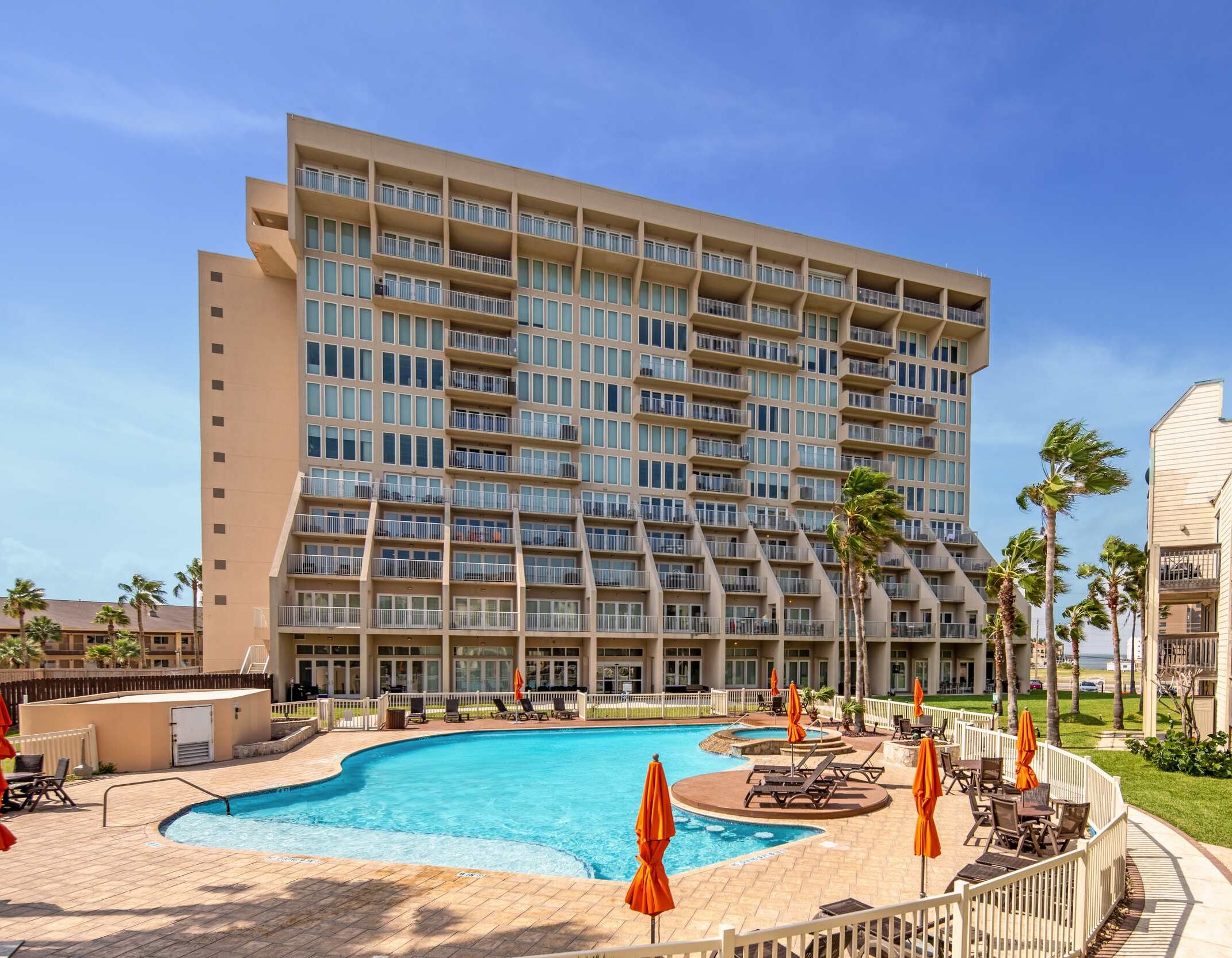 Un hôtel doté d’une grande piscine, de nombreux balcons et d’un espace extérieur bien entretenu.