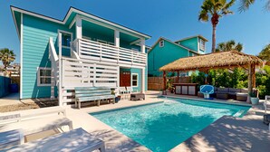 A turquoise house with a pool, white deck, and outdoor furniture. - Private Pool, Palapa, Golf Cart Access (Port Aransas)