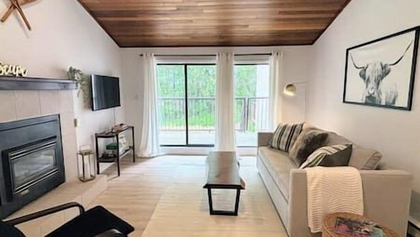 A living room with a fireplace, a sofa, a coffee table, and a television.