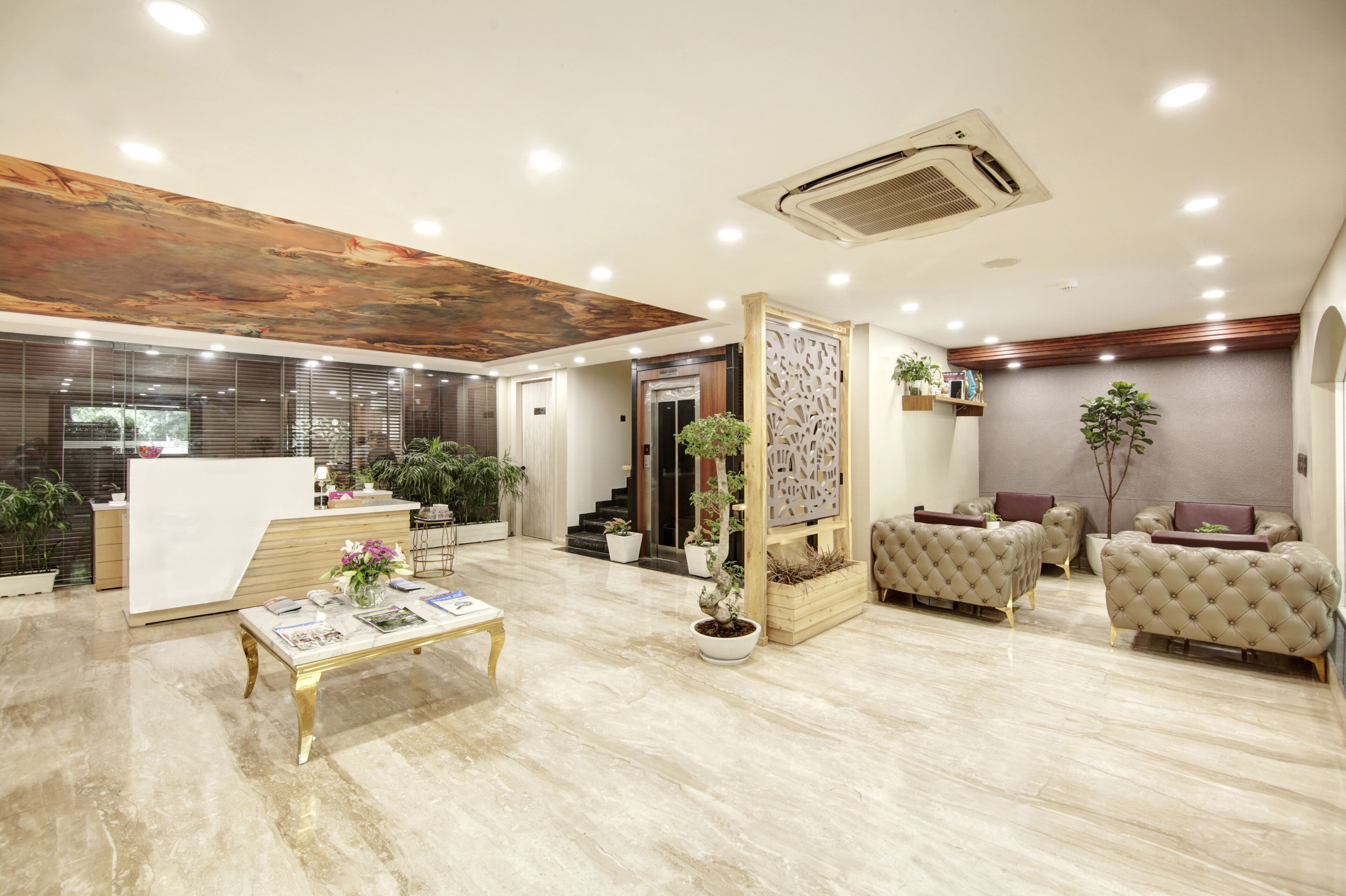 A modern reception area with a reception desk, seating area, and a staircase leading to an elevator.