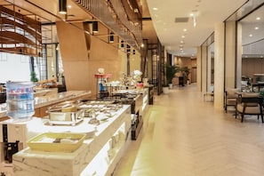 A hotel lobby with a long reception counter, seating area, and a modern staircase. - Delphi SKY Airport Hotel (Nanning)