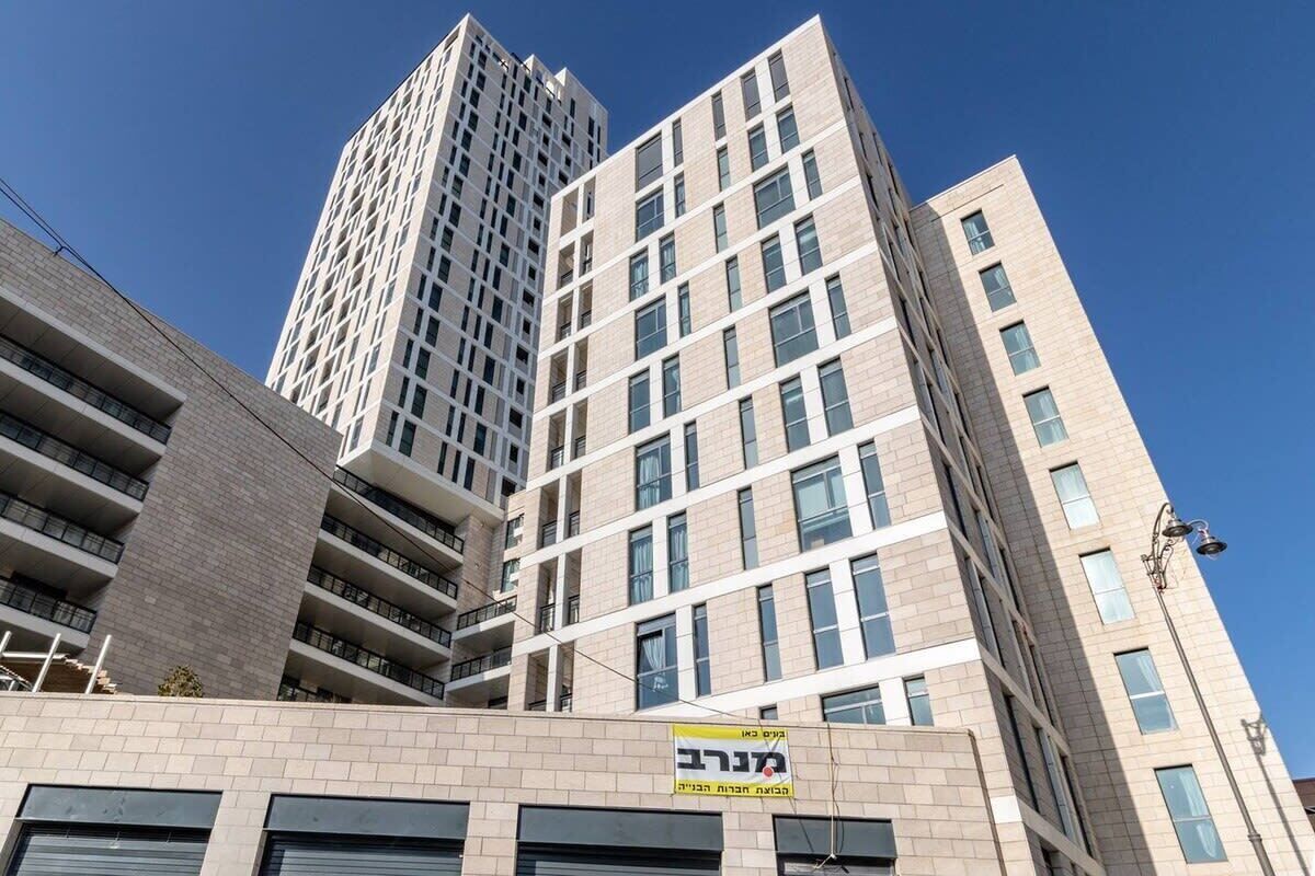 A multi-story building with a modern architectural design, featuring a mix of glass and brick facades.