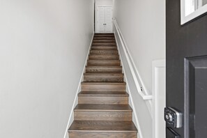 A staircase with wooden steps leading to a white door at the top.