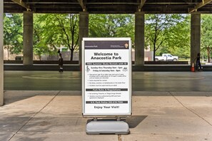 Un cartel en el Parque Anacostia que detalla alquiler gratuito de patinetas en verano, requisitos de identificación y normas del parque.