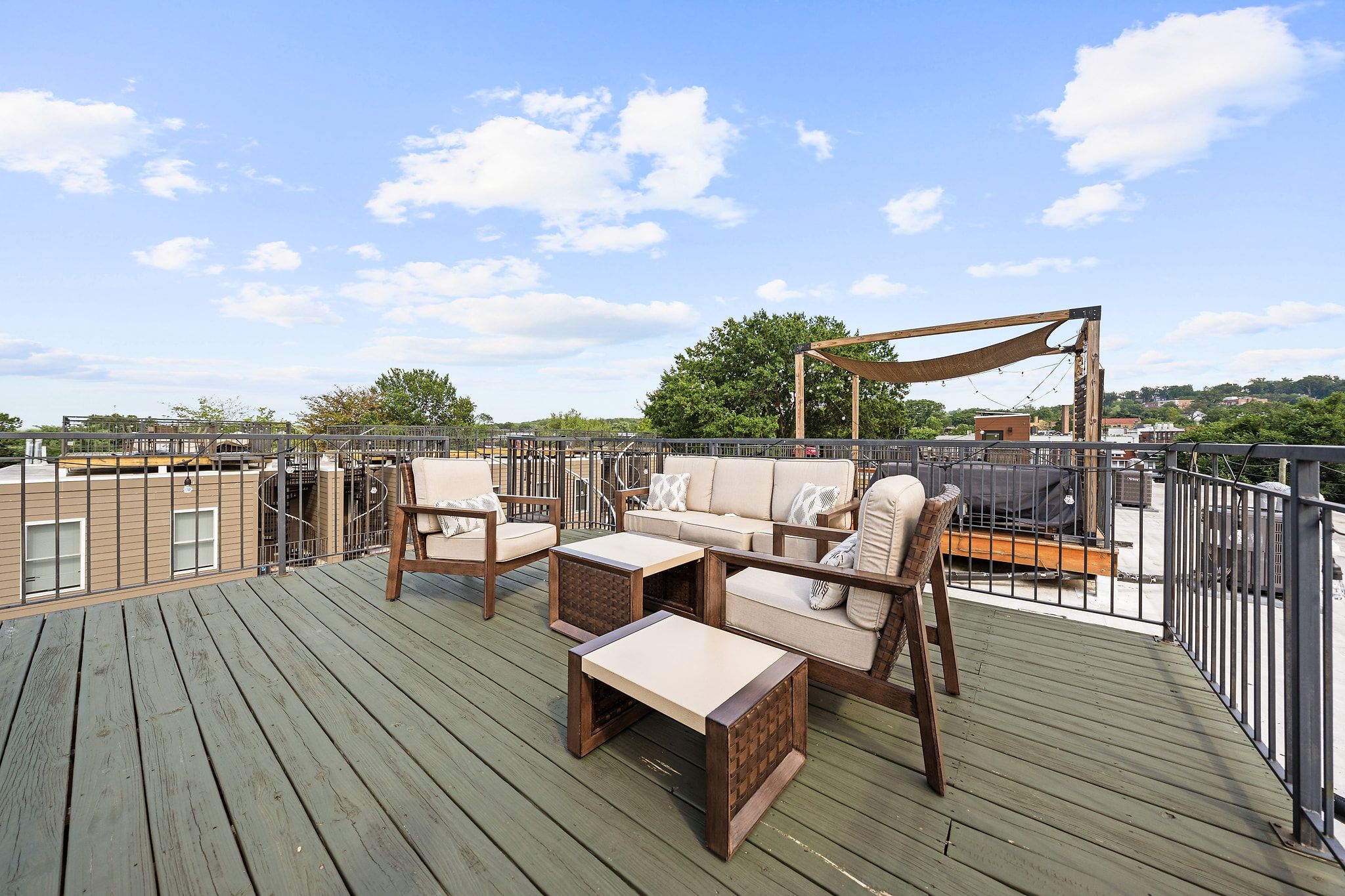 Eine Dachterrasse mit Gartenmöbeln, einer Pergola und Blick auf die Stadtlandschaft.