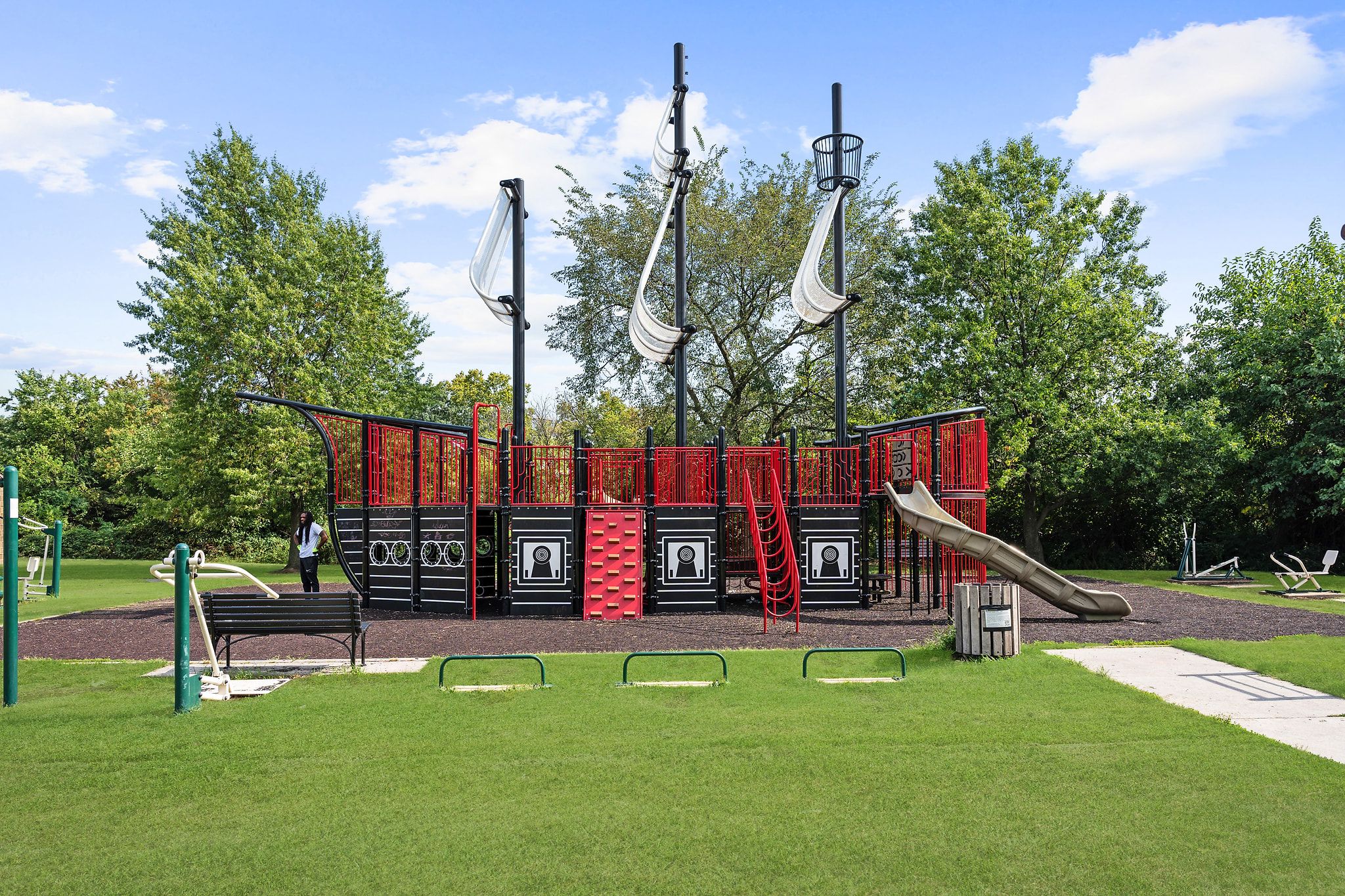A playground with slides, climbing structures, and a bench.