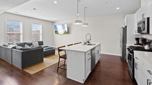 A modern kitchen with white cabinetry, a central island, and a built-in oven.