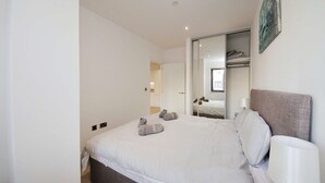 Una camera da letto moderna con un letto grande, una lampada da comodino e uno specchio.