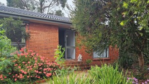 A brick house with a tiled roof, a small front porch, and a statue. - Mornington peninsula getaway (Frankston)