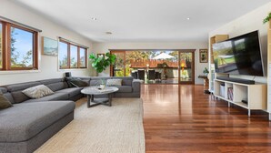 A modern living room with a grey sectional sofa, a coffee table, and a flat-screen TV.