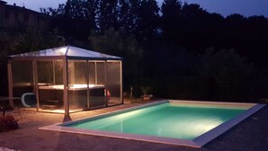 Une piscine dotée d’un espace détente abrité et d’une terrasse.