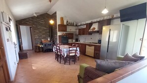 Une cuisine spacieuse avec un coin repas, un four encastré et un réfrigérateur.