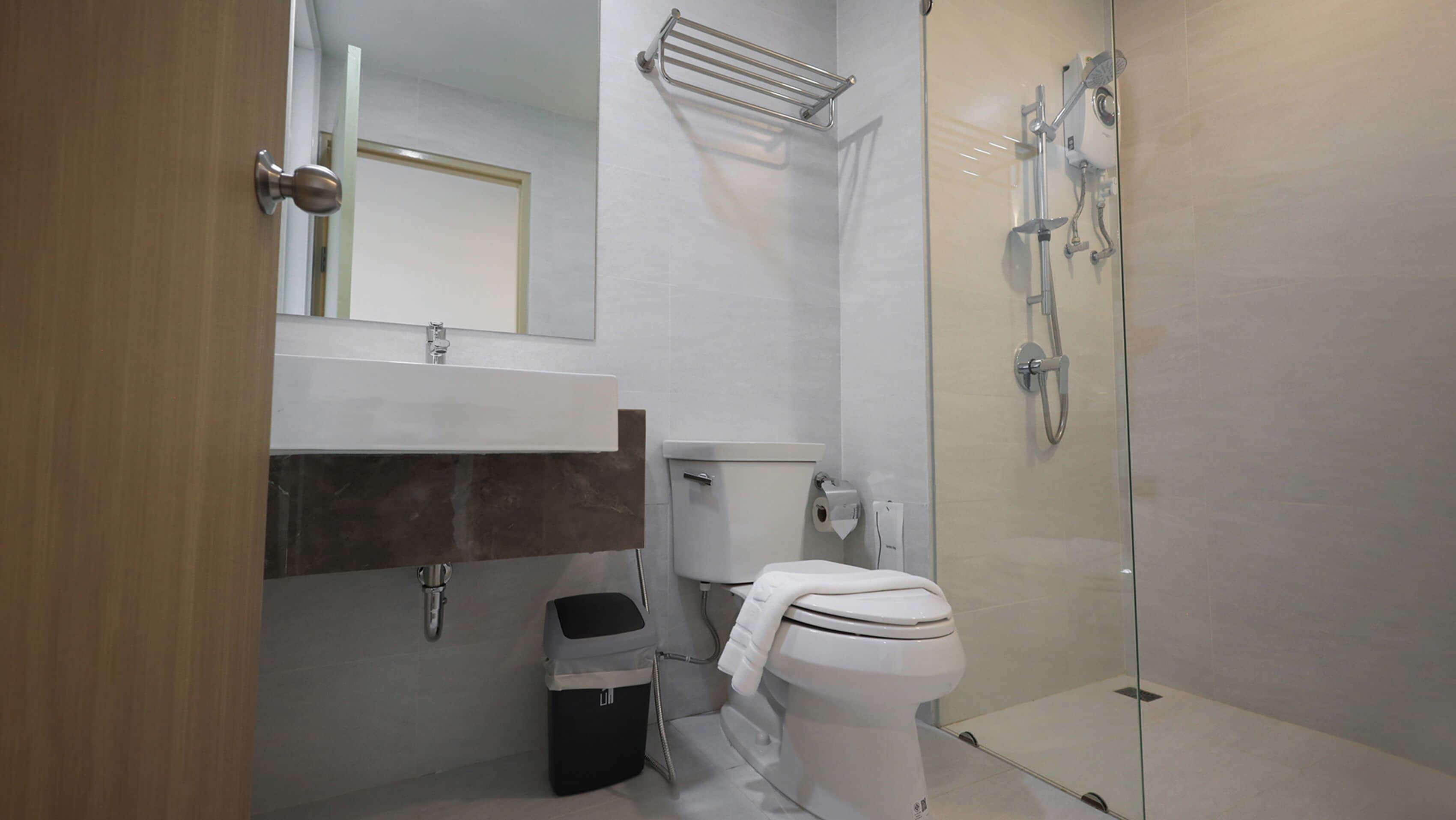 A modern bathroom with a toilet, sink, and shower.