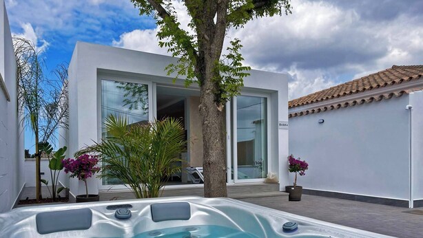 A modern outdoor hot tub area with a clear view of a contemporary house in the background. - Apartamento Klandestina - Ole Solutions (Conil de la Frontera)