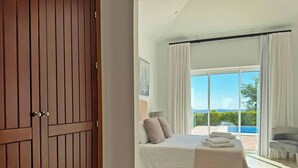 A bedroom with a large bed, a view of a pool, and a balcony. - Villa Los Olivos - Ole Solutions (Arcos de la Frontera)