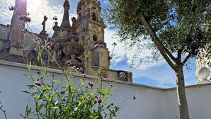 A building with a bell tower and a large tree in front. - Apartamento San Miguel - Ole Solutions (Jerez de la Frontera)