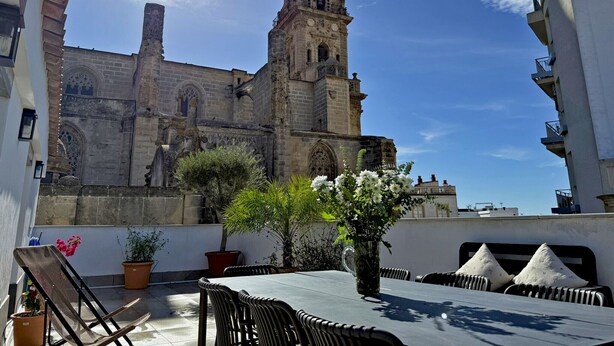 A rooftop terrace with a table, chairs, and potted plants. - Apartamento San Miguel - Ole Solutions (Jerez de la Frontera)