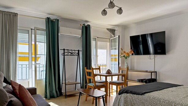Una habitación de hotel con cama, televisión, escritorio y silla.