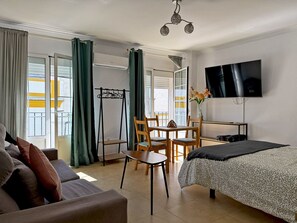 A hotel room with a bed, a TV, a desk, and a chair.