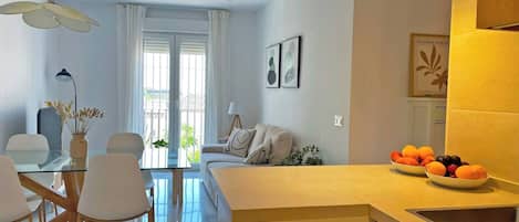 Un apartamento moderno con zona de comedor, cocina y sala de estar.