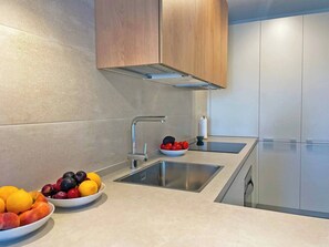 Una cocina moderna con dos fregaderos, un grifo de acero inoxidable y armarios de madera.