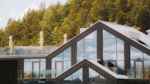 A modern building with large glass windows and a triangular roof design. - Season Hotel (Ekerö)