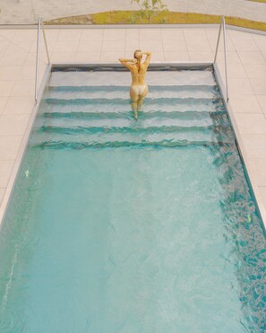A swimming pool with a person standing at the edge. - Season Hotel (Ekerö)