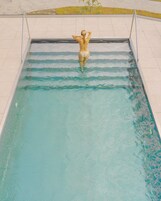 A swimming pool with a person standing at the edge.