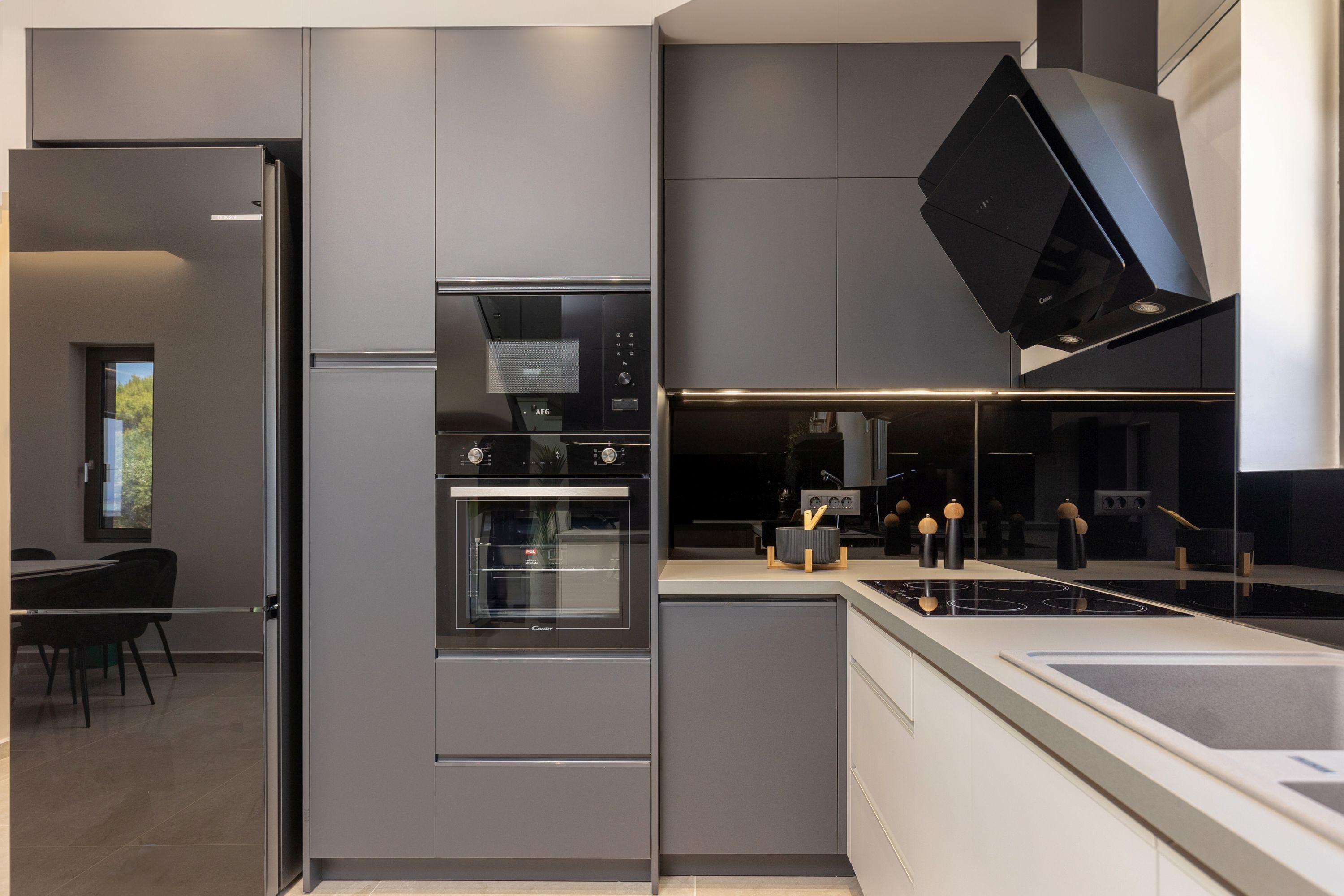 A modern kitchen with a built-in oven, a microwave, and a gas stove.