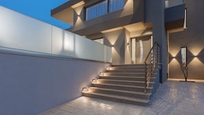 A modern building with a staircase leading to a second floor, a large window, and a small tree in the foreground. - Villa Frantzeska (Zakynthos)