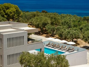 A modern hotel with a rooftop pool, lounge chairs, and umbrellas. - Villa Frantzeska (Zakynthos)