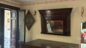 A room with a wooden desk, a mirror, and a door leading to another room. - Foresteria Lombarda B & B Cà Pelitti - Room with French bed (Ganna)