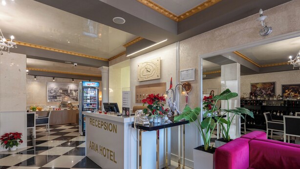 A reception area with a check-in counter, a bar, and seating arrangements. - Hotel Aria (Tirana)