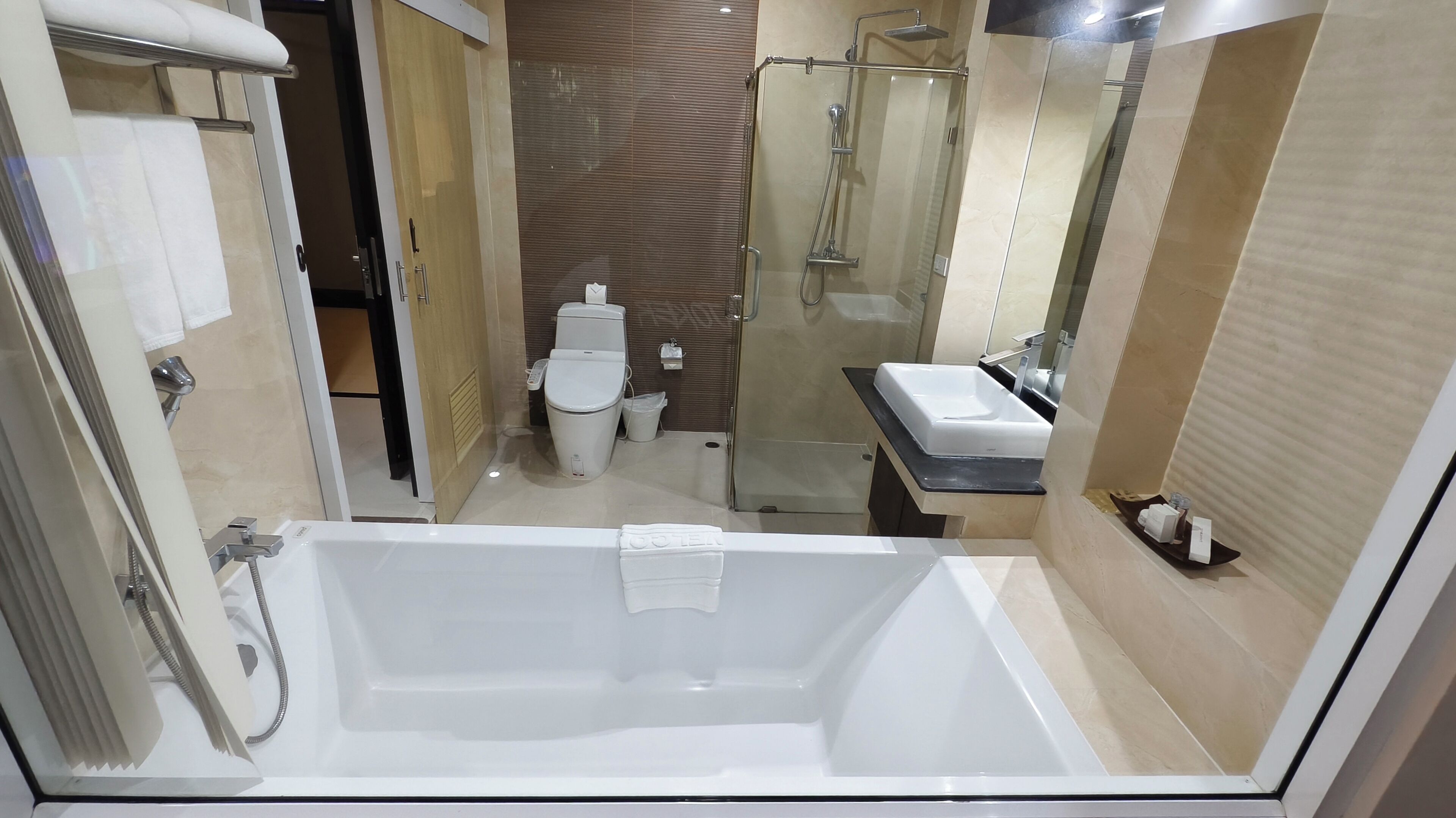 Un baño moderno con bañera, inodoro y zona de ducha.